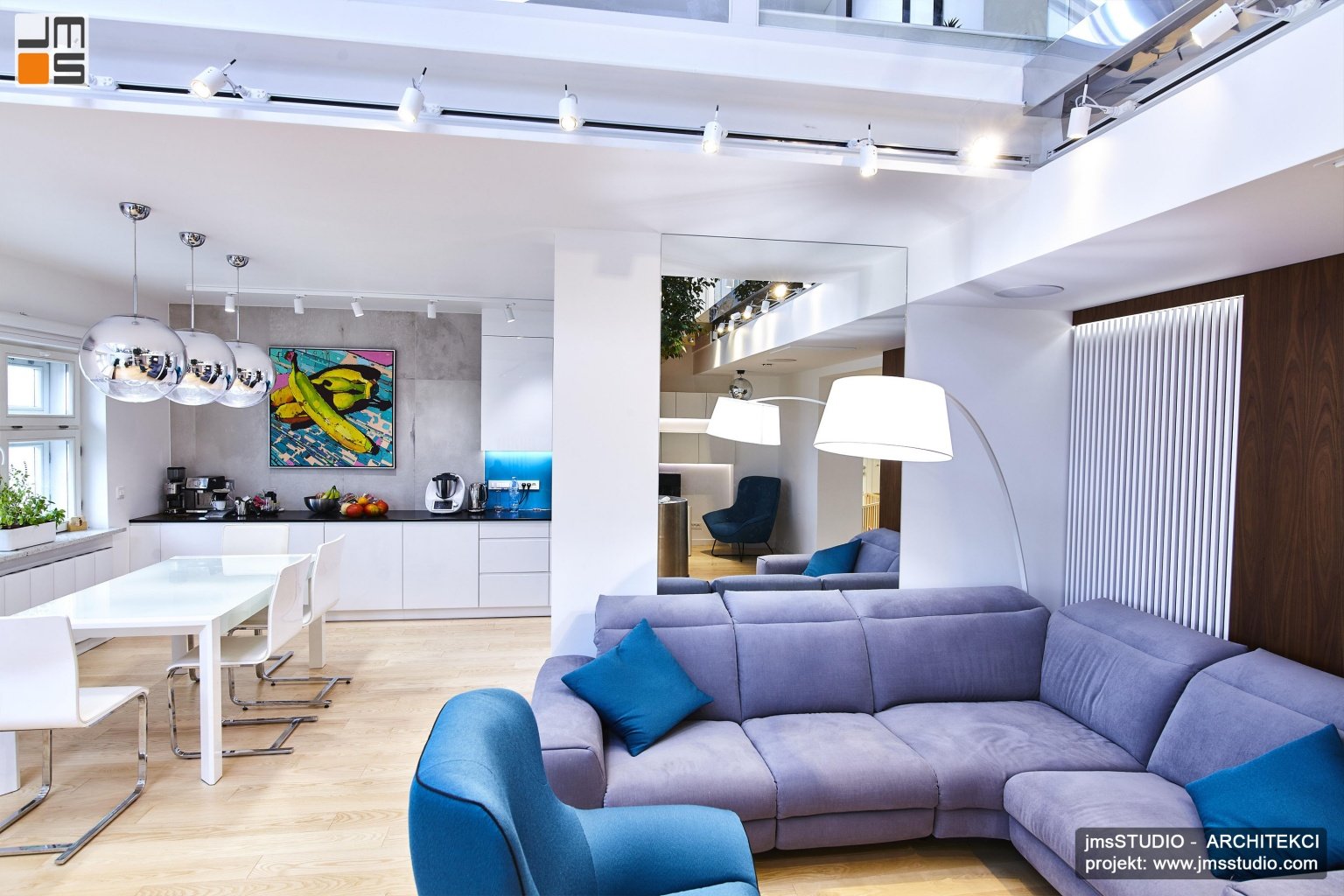 Duży rozłożysty wypoczynek w kolorze szarym idealnie pasuje do projektu wnętrz apartamentu dwupoziomowego o nowoczesnym wystroju