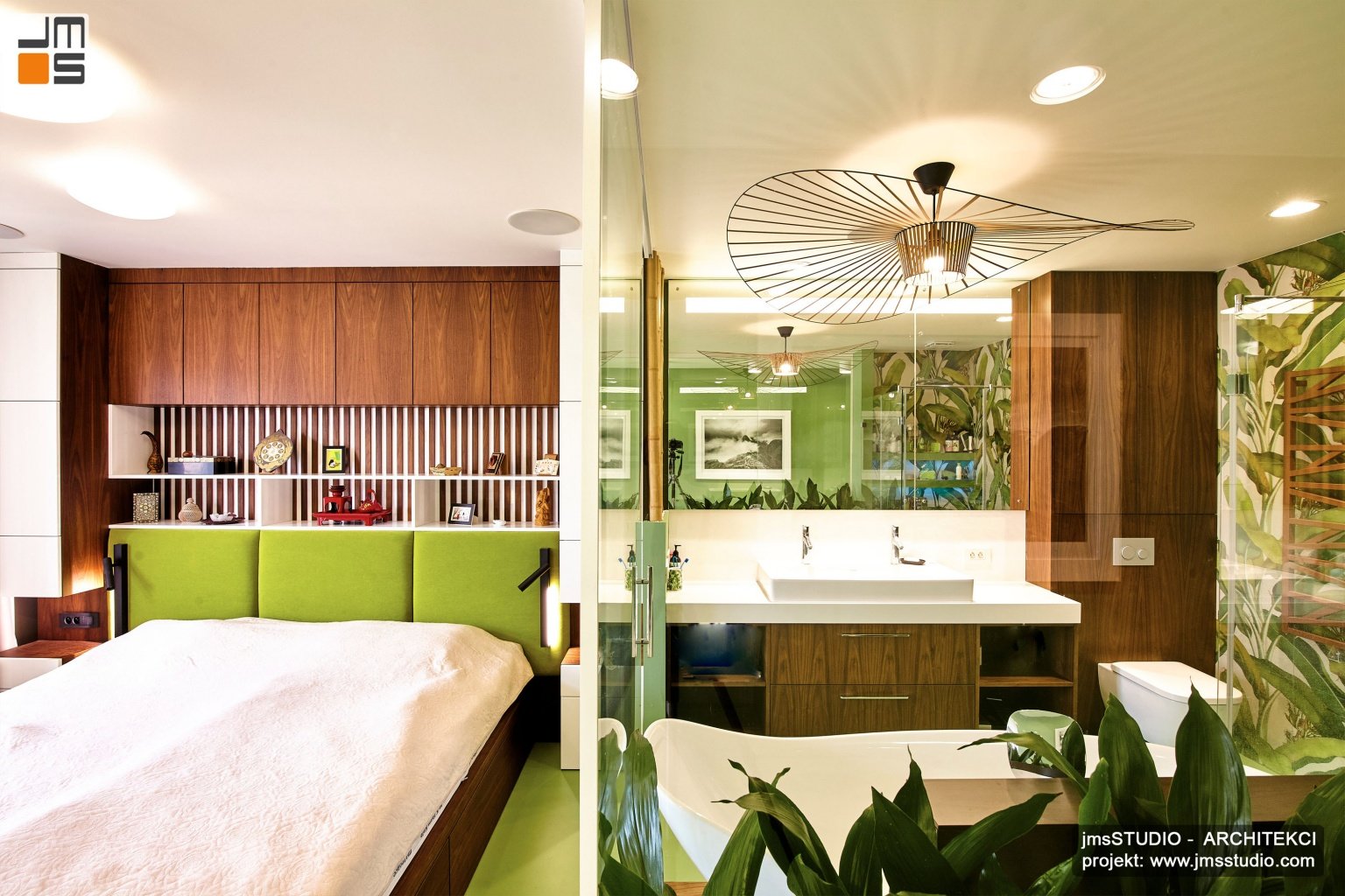 Piękna spójna kolorystyka projektu wnętrz to zielenie i ciepłe drewno połączone z bielą i kremem jest to projekt sypialni połączonej z łazienką w apartamencie w Kraków