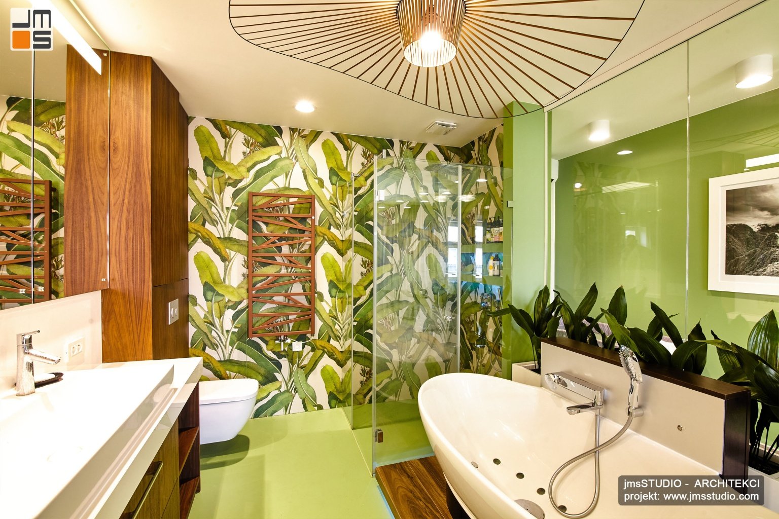 W przestronnym salonie kąpielowym z wanną stojącą projekt wnętrz z ciekawą lampą i płytkami z motywem roślinnym i drewno naturalne