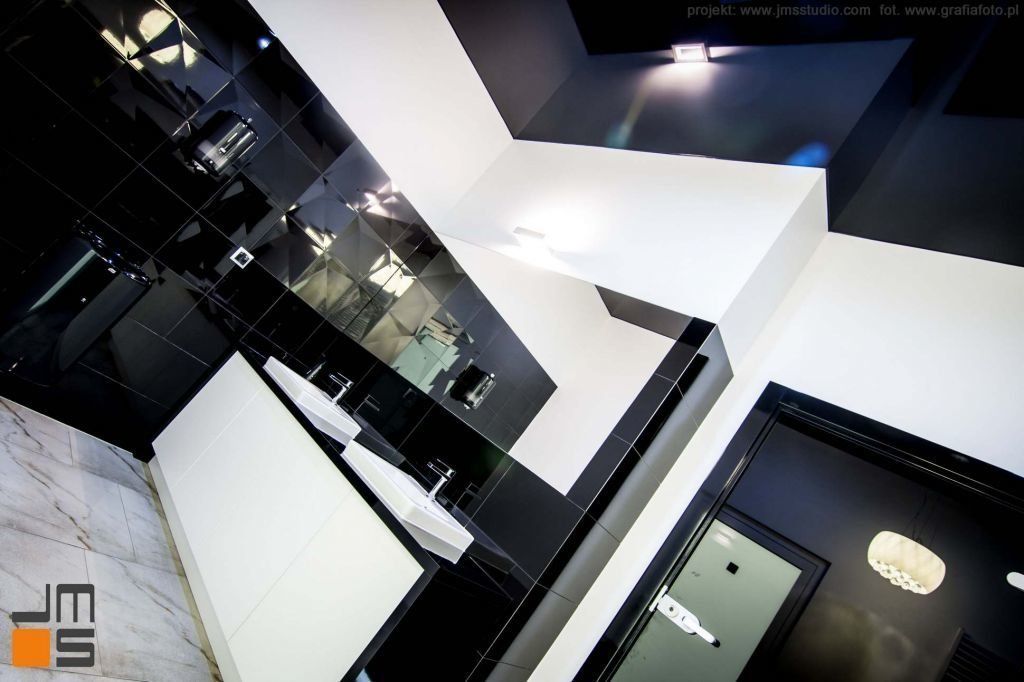 Ciemne odbijające lustrzane powierzchnie w aranżacji wnętrz nowoczesnej łazienki w biurach