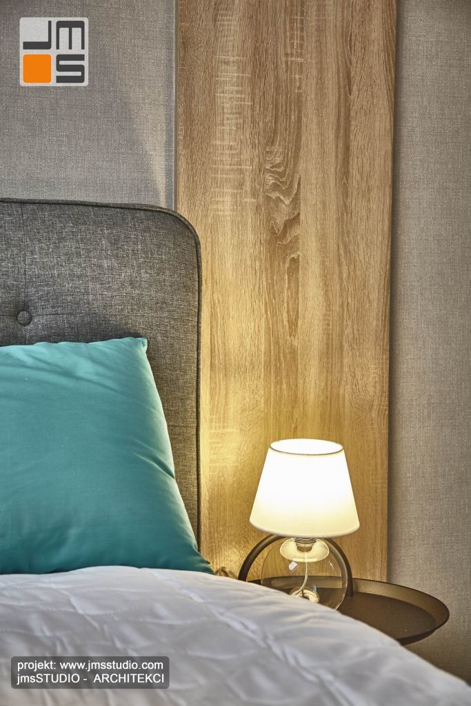 Połączenie trzech różnych materiałów drewno tapeta i ktanina tapicerki w nowoczesnym wnętrzu sypialni.