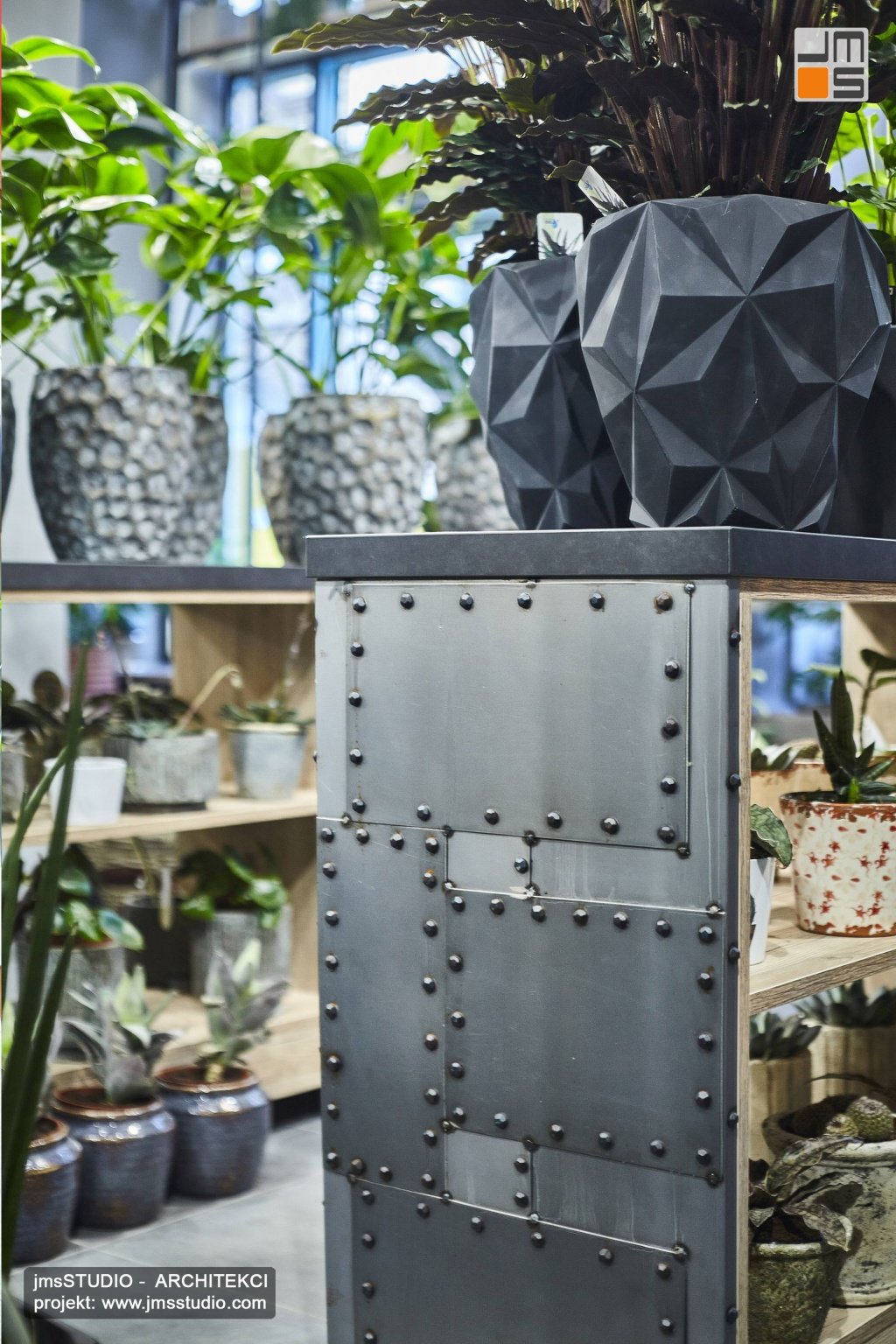 Designerskie stalowe nitowane meble to pomysł na projekt wnętrz nowoczesnej kwiaciarni w Krakowie