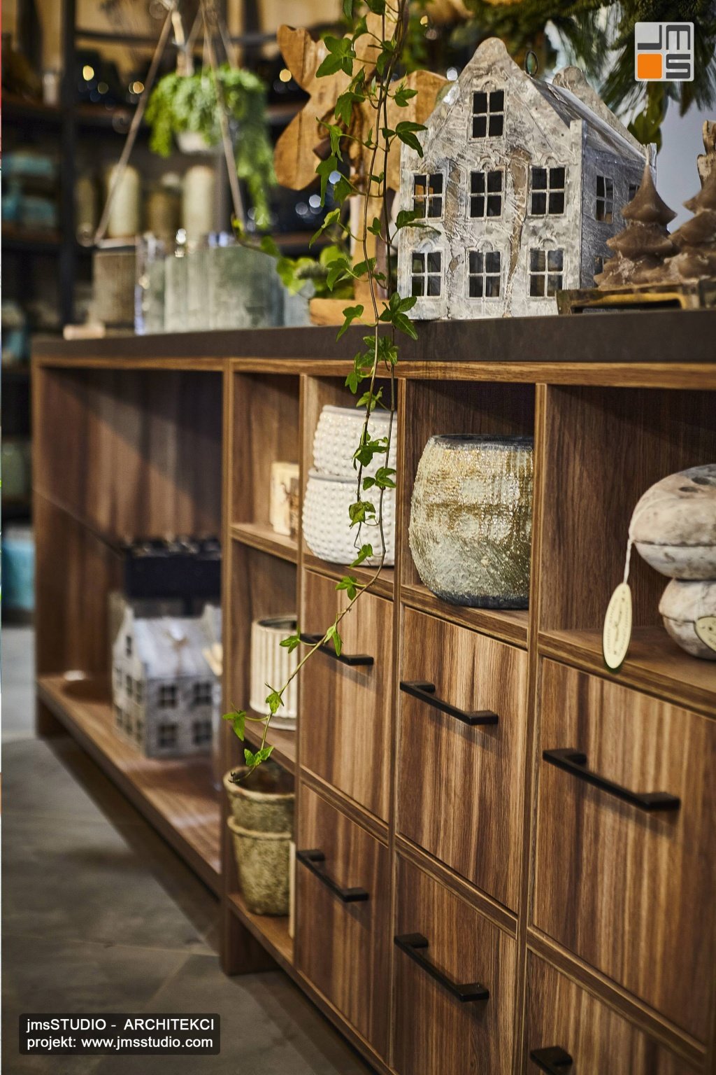 Drewniana komoda projektowana na zamówienie w fornirze orzechowym to elegancki ekspozytor w projekcie wnętrz kwiaciarni w Krakowie