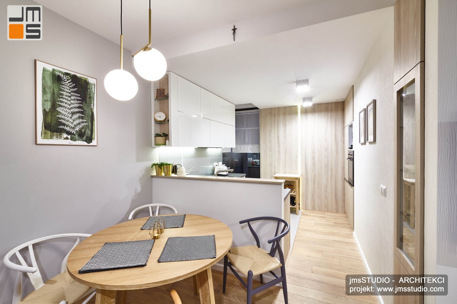 Projekt wnętrz kuchni to bardzo proste meble w jasnych kolorach biel i drewno z pomysłem na ścianę z drewna