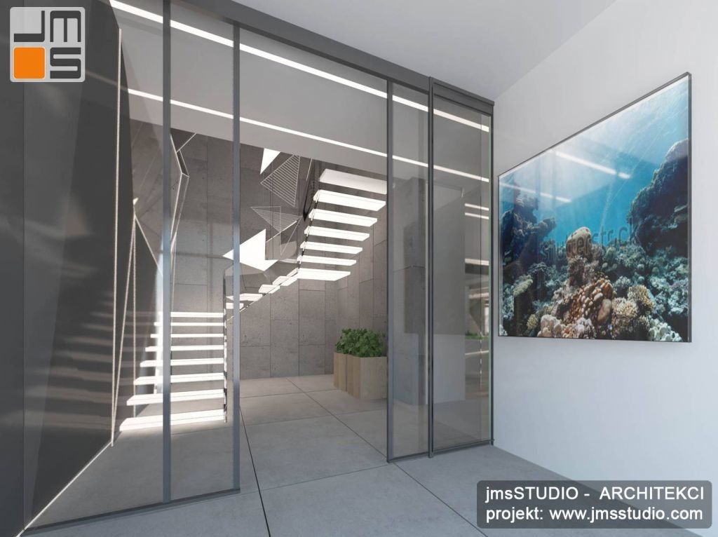 projekt wnętrz holu wejściowego do nowoczesnego domu jednorodzinnego z akwarium morskim i betonem architektonicznym we wnętrzu