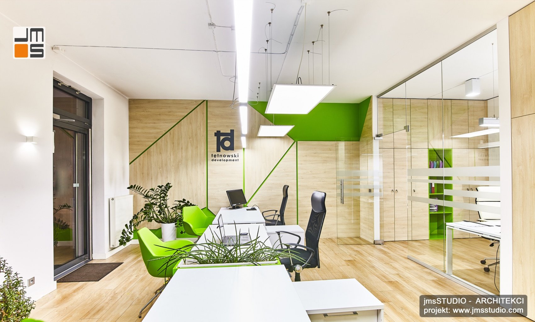 Na ścianach w biurach w Krakowie zastosowano ciekawe panele dekoracyjne z drewna i zielonego szkła.
